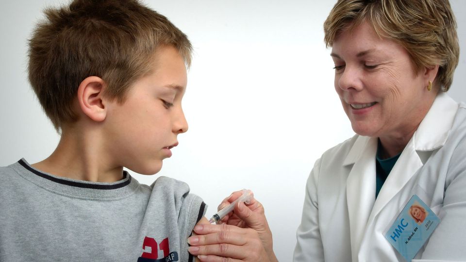 A child receives an injection from a clinician.