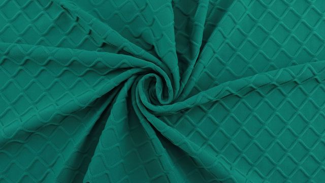 A stretchy, patterned green fabric pulled into a swirl shape. 